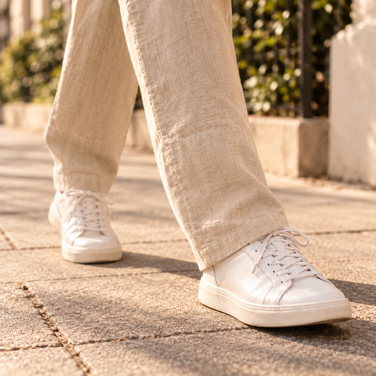 A person walking in trousers and trainers with ankles fully covered